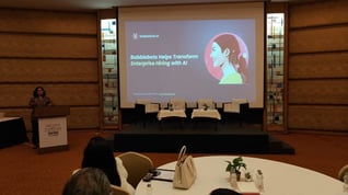 Conference stage with a presentation slide on AI-driven hiring, illustrating Babblebots sharing insights on voice AI in recruitment.