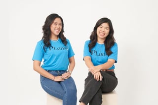 OvyHealth team in matching blue T-shirts, smiling and seated against a white backdrop, featuring in Tech in Asia. 