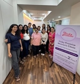 Pinky Promise's team standing in the newly opened women's clinic in Andheri West, Mumbai, in front of a Pinky Promise banner